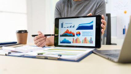 A housewife in a grey t-shirt works from home at a desk with a whiteboard, managing financial tasks like accounting, auditing, and financial advisory services with professionalism and dedication.