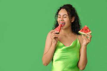 Happy young African-American woman with fresh watermelon on green background