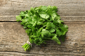 Bunch of fresh coriander on wooden table, top view