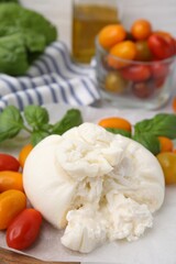 Delicious fresh burrata cheese with tomatoes on table, closeup