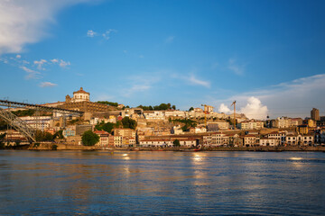 Naklejka premium View of Vila Nova de Gaia city riverfront with Mosteiro da Serra do Pilar monastery and Dom Luis I bridge over Douro river on sunset. Porto, Vila Nova de Gaia, Portugal
