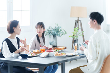 朝食を食べる親子　女の子とお父さん、お母さん