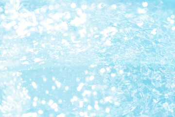 Blue water with ripples on the surface. Defocus blurred transparent blue colored clear calm water surface texture with splashes and bubbles. Water waves with shining pattern texture background.