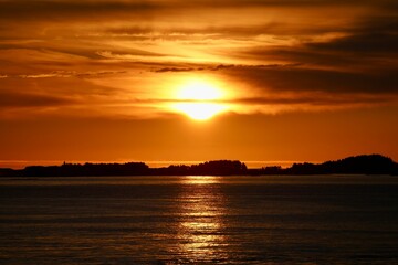 Rising sun peaks above the ocean between Molde and Kristiansund, Norway