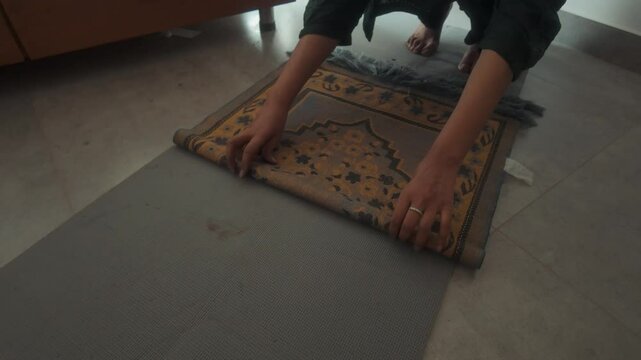Close-up video of a muslim women folding a prayer mat after offering namaz.