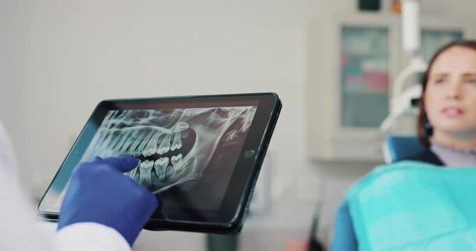 Dentist, surgery and tablet screen for patient, x ray and consultation of woman, appointment and checkup. Office, person and doctor with explanation of gum disease, talking and treatment for teeth