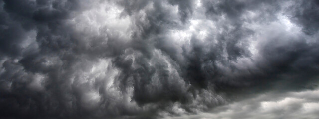 Banner Dramatic dark storm clouds black sky background. Dark thunderstorm clouds rainny season. Panorama Meteorology danger windstorm disasters climate. Dark cloudscape storm cloud with copy space.