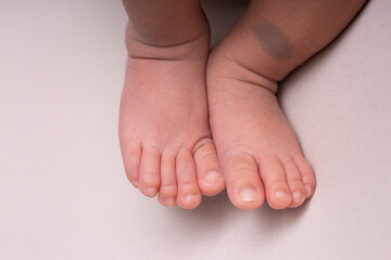 Little newborn baby human feet with toes and toenails close up
