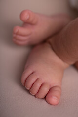 Little newborn baby human feet with toes and toenails close up
