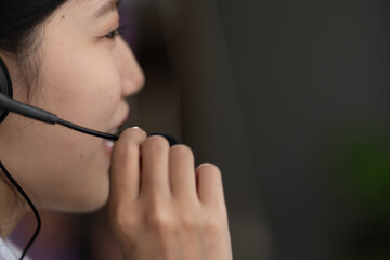 Obraz premium Contact center and customer service using headphones concept, beautiful Asian woman working in office wearing headset and use a laptop computer to chat to support customers at work