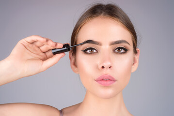 Fototapeta premium Woman comb eyebrows with eyebrow brush. Care for brows, eyebrows lamination. Brow beauty procedures. Beautiful woman with long eyelashes, eyebrows.