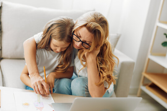 Mother and daughter bonding in a cozy living room, working on homework with love and support
