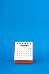 September 2024 white desk calendar on blue background.