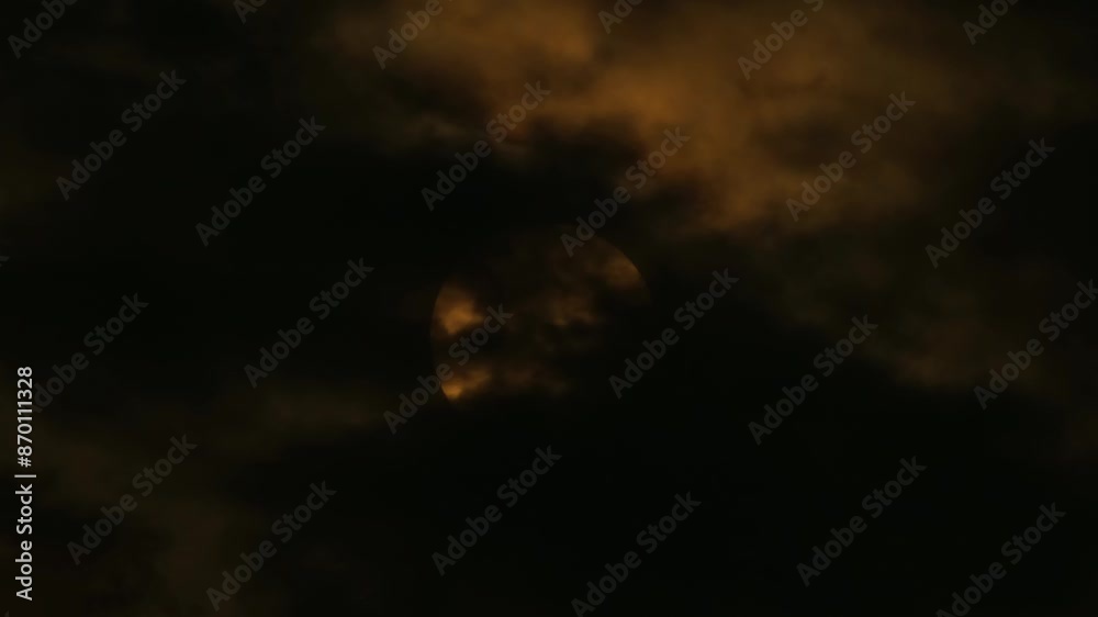Wall mural a full moon emerging majestically through the dark night clouds - timelapse