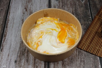 Classic scramble egg serving in the paper box. Famous breakfast delivery menu in Asia. Mock up of frozen food product. High protein and nutrition concept.
