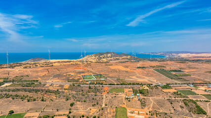 Panoramic view of wind farm or wind park, with high wind turbines for generation electricity with...
