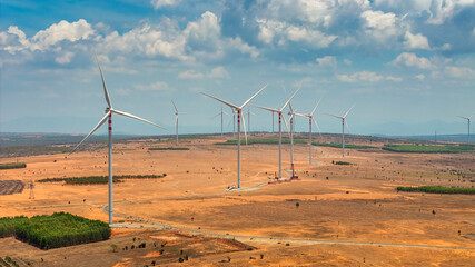 Windmill park with clouds and a blue sky, wind mill turbines in the ocean aerial view of a wind farm in the Bau Trang sand hill, Binh Thuan, Vietnam production clean energy