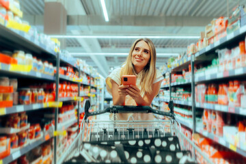 
Happy Customer with Mobile Phone Shopping in a Supermarket
Woman looking on her phone to see what...