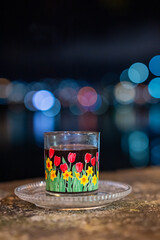 A glass of coffee with a bokeh background of dim lights