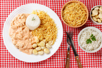 Homemade chicken stroganoff in ceramic plate on red checkered tablecloth