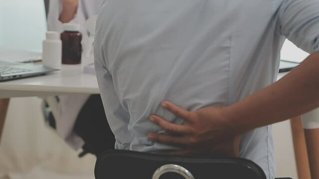 Orthopedists holding digital tablet and pointing at model. Concept of osteoporosis, back pain, lumbar, chiropractic and health.