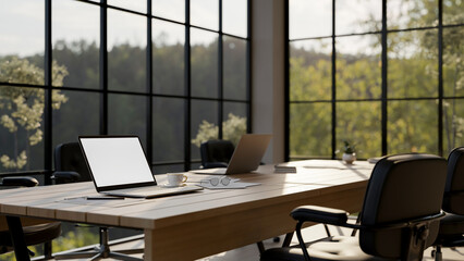 A laptop computer with a white-screen mockup on a wooden meeting table in a modern meeting room.