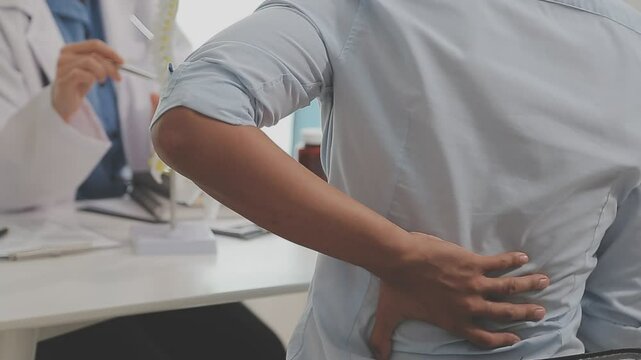 Orthopedists holding digital tablet and pointing at model. Concept of osteoporosis, back pain, lumbar, chiropractic and health.
