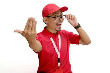 Excited Asian delivery man or courier Beckoning with extends a 'come here' gesture towards the camera, inviting viewers to come closer or join him, isolated on a white background