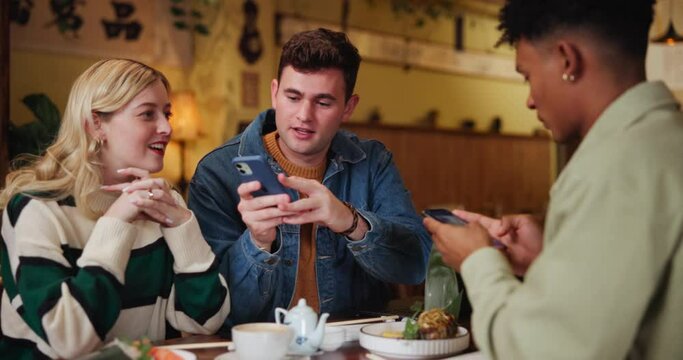 Friends, people and happy with smartphone in cafe for networking, social media and fun. Date, conversation and happy with date or lunch with coffee as gen z to enjoy, relax and conversations