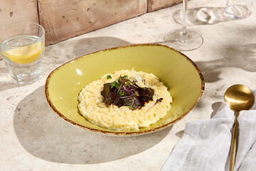 Elegant Still Life of Orzo Pasta with Veal Cheeks in Natural Sunlight on Beige Table