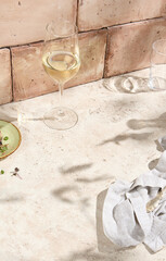 Sunlit Still Life on Beige Table with White Wine Glass, Refined Lifestyle Aesthetic