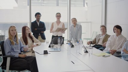A diverse group of successful young professionals meet in a modern office for a corporate business meeting, emphasizing collaboration, diversity, teamwork, and effective management