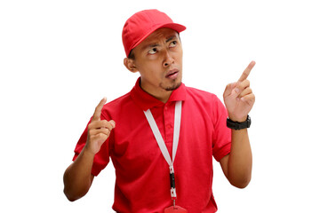 confused Asian delivery man or courier is pointing upward at an empty space, appearing perplexed and torn between choices, indicating confusion and uncertainty, isolated on a white background