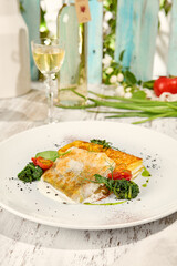 Sunlit Fried Fish with Potato Gratin on Rustic Wooden Table