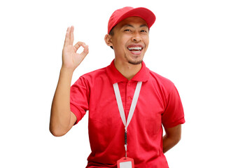 Excited Asian delivery man or courier showing an OK gesture at the camera, expressing satisfaction, approval, giving a good review, high rating, or positive feedback, isolated on a white background