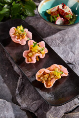 Exquisite Set of Salmon and Tuna Tartare Served in Rice Chips on Rustic Slate Plate