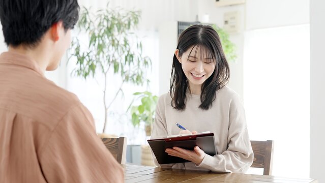 男性にインタビューをする女性