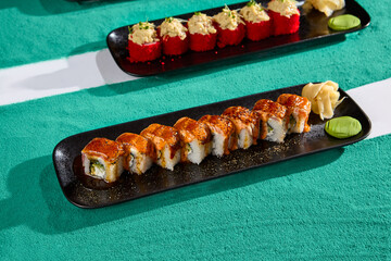 Seared Philadelphia Roll with Spicy Sauce on Black Plate