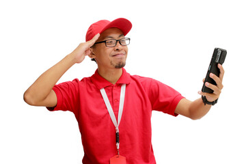 Excited Indonesian delivery man or courier celebrating Indonesian Independence Day, taking a selfie in a video call and making a salute gesture. Isolated on a white background