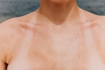 Close up of woman's chest with ocean in background