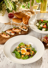 Rustic Food Composition with Salads and Appetizers in Sunlit Setting on Wooden Table
