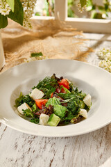 Fresh Greek Salad in White Bowl with Summer Still Life Background, Sunlit Wooden Surface