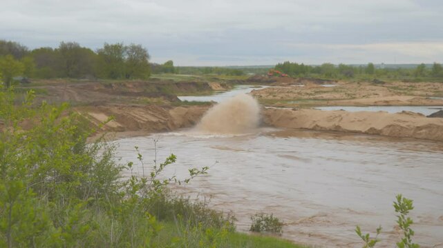 Dirty water is flowing from the pipe. Sand mining