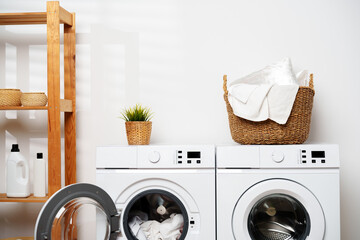 Laundry Day in a Modern Home With White Washers and a Wooden Shelf © fotofabrika