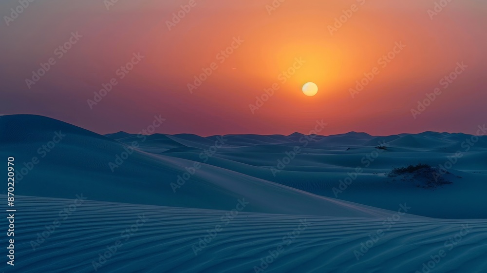 Poster The gentle hues of a desert sunset, with the sun setting behind sand dunes, create a serene and otherworldly landscape.