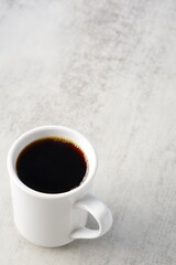 朝のひと時、お気に入りのマグカップに淹れたての美味しいコーヒーを入れてひと休みしているイメージ