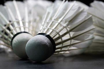 Close-up shot of badminton shuttlecock on black background used in competition.