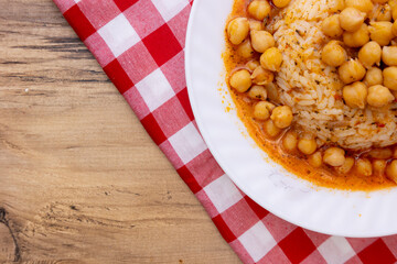 Close-up of a chickpea and rice dish on a red checkered napkin, highlighting the details and colors of the meal.