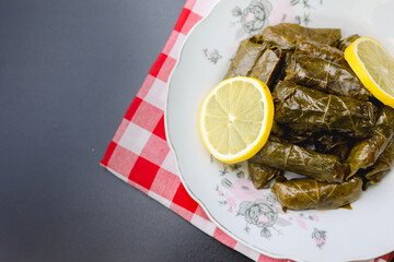 Close-up of stuffed grape leaves on a red checkered napkin, highlighting the texture and presentation.