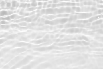 White water with ripples on the surface. Defocus blurred transparent white colored clear calm water surface texture with splashes and bubbles. Water waves with shining pattern texture background.